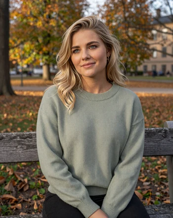 Linnéa, 32, Swedish woman from Gothenburg sitting in an autumn park with gentle smile