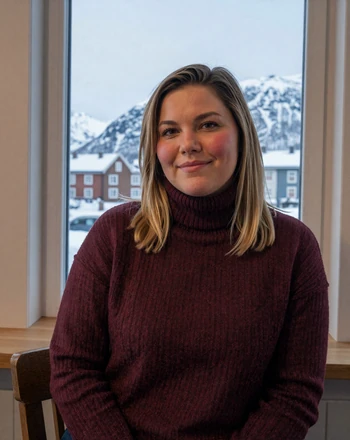 Liv, 34, Norwegian woman from Tromsø sitting in a cozy coffeehouse with snowy mountains outside